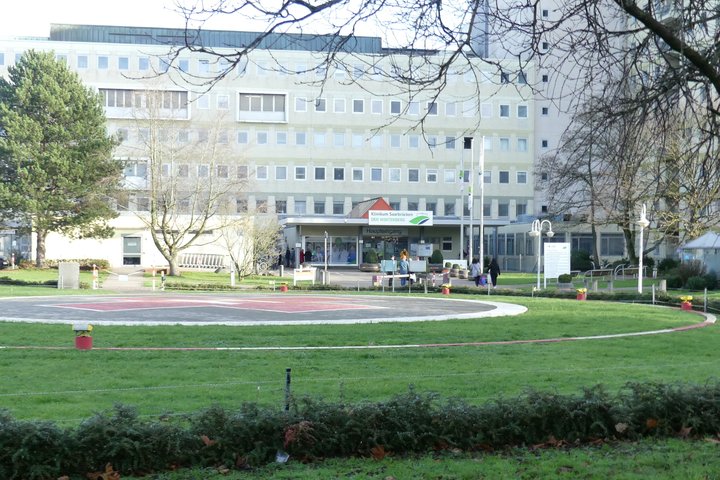 Ansicht von vorne auf das Krankenhaus Winterberg. Die Parkanlage mit dem  Hubschrauberlandeplatz