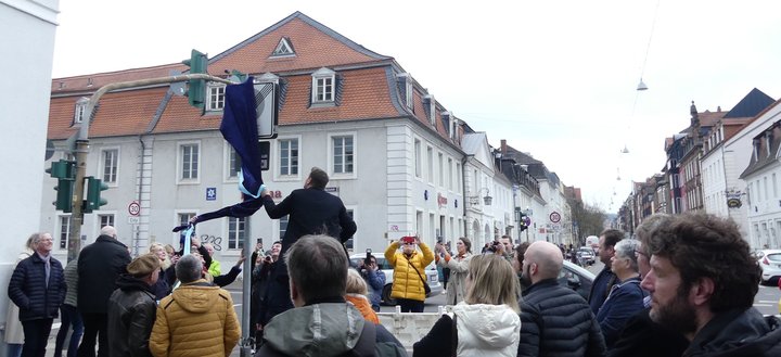 Saarbrückens Oberbürgermeister Uwe Conrad bemüht sich, das neue Verkehrsschild "Fußgängerzone" zu enthüllen